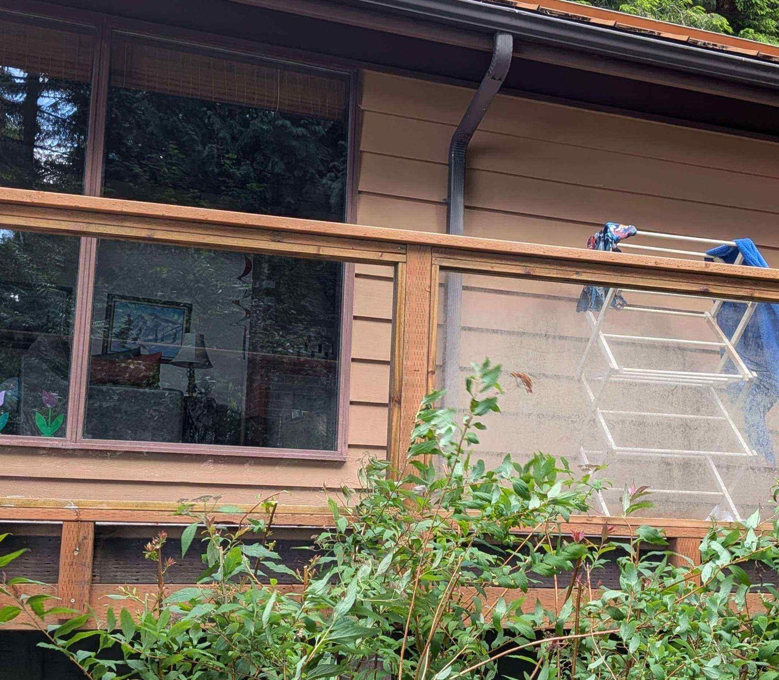 Exterior deck and window area mid-cleaning, with cleaning equipment set up on the deck rail