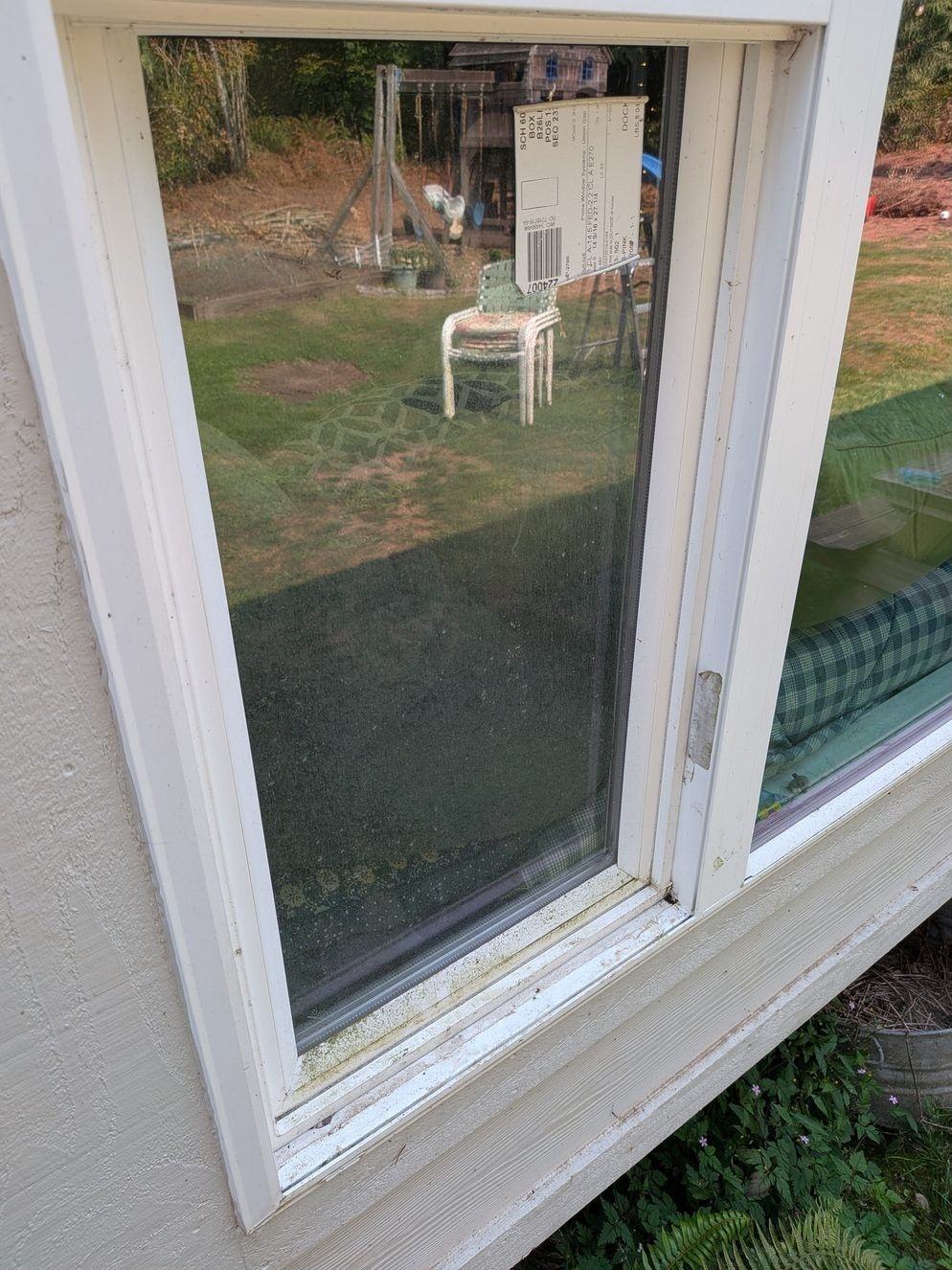 Hazy, spotted exterior window glass and frame before cleaning