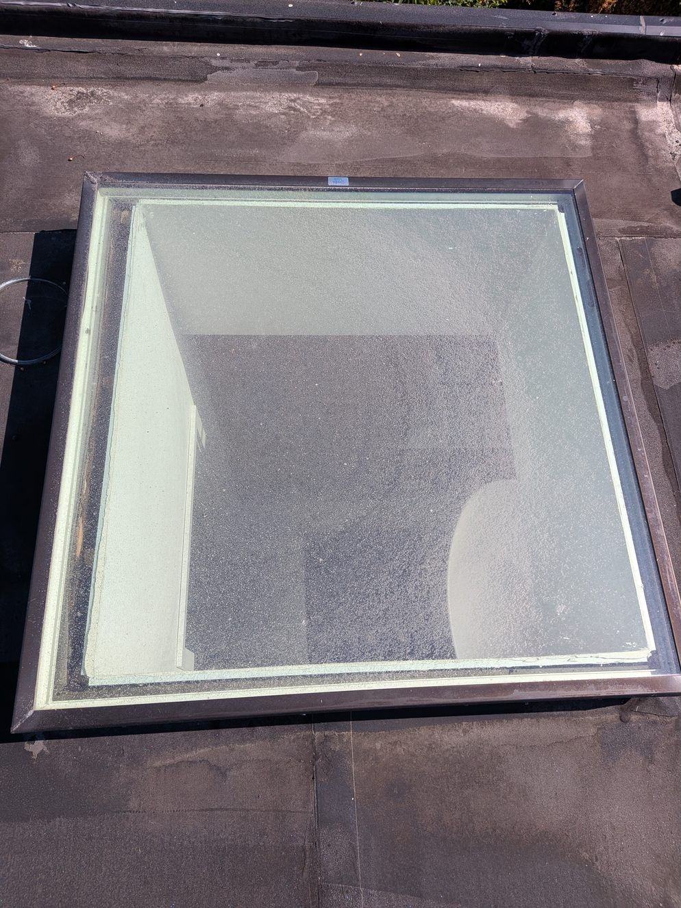 Cloudy, film-covered skylight glass before cleaning