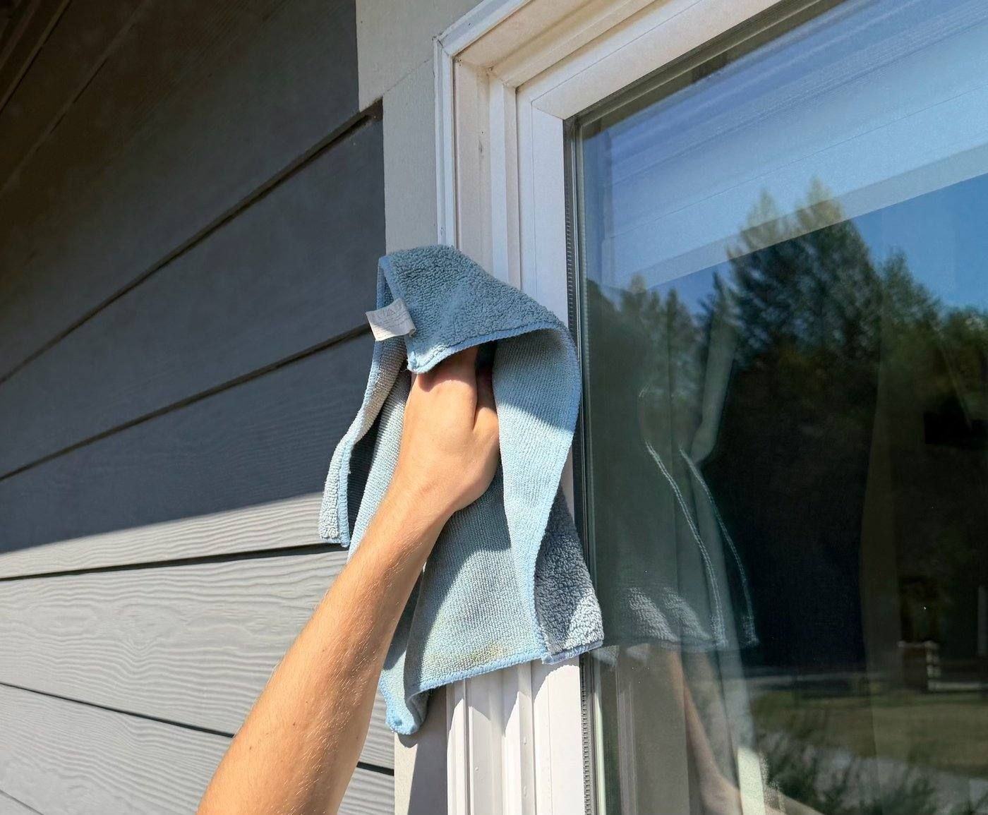 Hand-scrubbing a window with a soapy applicator